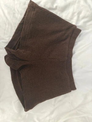 Bruna stickade shorts - Mysiga bruna stickade shorts med mellanhög midja. Perfekta för en avslappnad och trendig look. Mjukt material som känns skönt mot huden och ger en chill vibe.