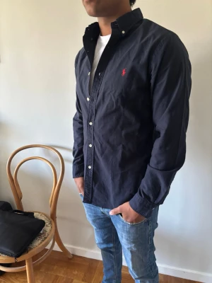Mörkblå Ralph Lauren M - Säljer min Polo Ralph Lauren skjorta då jag inte använder den. Har använt den en gång. Perfekt att ha nu till sommaren för en skön sommar outfit. Det är slimfit i storlek M.                  Tveka inte på att höra av dig vid frågor! 🔥🙏