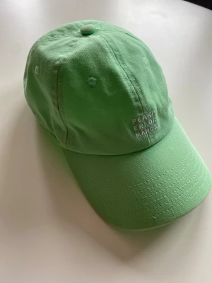 Mintgrön keps från Peak Performance - Snygg Peak Performance keps i mintgrön färg. Välanvänd men fortfarande jättefin👌    •  Märke: Peak Performance   •  Modell: Ground Cap G64948012T   •  Färg: 4EA Mintgrön med vit broderad logga fram  •  Storlek: One Size, justerbar med metallspänne baktill  •  Material: 100% bomull   •  Skick: Bra skick. Tvättad, inga fläckar eller hål. Färgen har endast blekts lite naturligt av solen, men den ser fortfarande fräsch ut.