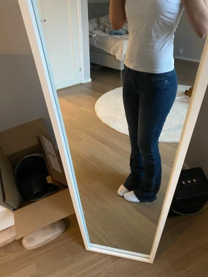 Mörkblå bootcut jeans från ONLY - Säljer ett par mörkblå bootcut jeans från ONLY med klassisk femficksmodell och normal midja. Jeansen har en snygg tvätt och är tillverkade i mjukt denimtyg som sitter skönt. Perfekta för dig som gillar en tidlös och avslappnad stil.