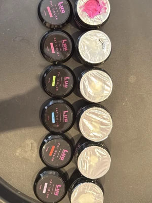 Luu Pat Color nagellack set - Säljer ett set med Luu Pat Color nagellack i flera olika färger, inklusive rosa, grön, orange och blå. Nagellacken kommer i små runda burkar med svart lock och färgmarkering på etiketten. Perfekt för dig som gillar att experimentera med nageldesign. 50kr styck, 290