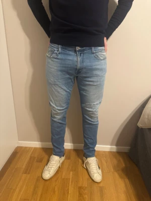 Ljusblå slim fit jeans från replay - Säljer ett par ljusblå slim fit jeans från replay Jeans med klassisk femficksmodell och diskreta slitningar på framsidan. Jeansen har normal midja, dragkedjegylf och är tillverkade i mjuk denim med stretch för extra komfort.