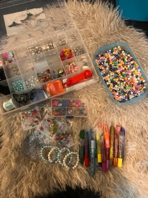 Stort pärl- och smyckeskit DIY - Säljer ett komplett DIY-kit för smyckestillverkning med massor av färgglada plastpärlor, bokstavspärlor, silverfärgade berlocker, elastiska trådar och olika smyckesdelar. Perfekt för att skapa egna armband, halsband och nyckelringar. Inkluderar även några färdiga armband och verktyg.