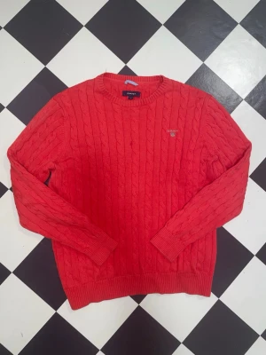 🌹En snygg Röd kabelstickad tröja från GANT✨ - ❤️✨ Röd kabelstickad långtröja från GANT ✨❤️  Superfin och klassisk kabelstickad tröja i en snygg röd färg 🔥 Perfekt nu till kallare dagar – både mysig och stilren!  🧵 Mycket bra skick – sparsamt använd och väl omhändertagen 🙌  📏 Storlek: L (passar mer som M) 📐 Mått: • Armlängd: 61 cm • Axelbredd: 47 cm • Längd: 64 cm  💸 Pris: 279 kr                                                               Först till kvarn!🏃‍♀️‍➡️🔥 