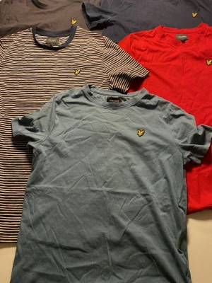 Flera T-shirts från lyle and Scott// 100kr st - Fem snygga t-shirts från Lyle & Scott i olika färger och mönster. En randig i blått och vitt, en röd, en ljusblå, en mörkblå och en mörkgrå. Alla har korta ärmar och den klassiska loggan på bröstet. Perfekta för en avslappnad stil.