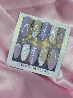 PurpleBijou (S);Medium Almond - Snygga handgjorda press-on naglar i lila och nudebeige med lila prickar och små silverpärlor. Mixade mönster på varje nagel och glansig finish. Medium-Mandelformade och trendiga, perfekta för dig som vill ha något unikt och kreativt på naglarna.S: 15 mm, 11,5 mm, 12 mm, 11 mm, 9 mm (Silver)