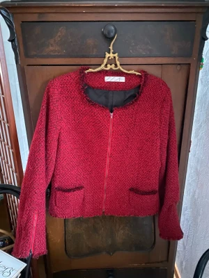 Röd cardiganjacka från Vero Moda - Röd cardiganjacka med grovstickad struktur och dragkedja framtill. Jackan har rund halsringning, två fickor och diskreta svarta detaljer. Perfekt för att addera färg till din outfit. (Möts upp i Stockholm)