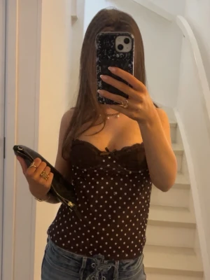 Brun prickig spetslinnetopp - säljer min superfina topp som är prickig, med lite spetts detaljer och en rosett i mitten, inköpt på plick för typ en månad sedan ❤️skriv om ni har några frågor 