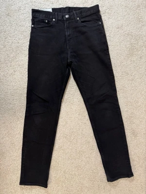 Svarta slim-fit jeans från H&M - Snygga svarta slim-fit jeans med klassisk design och silverfärgade nitar. Perfekta till en streetwear-look eller att matcha med en oversized hoodie.