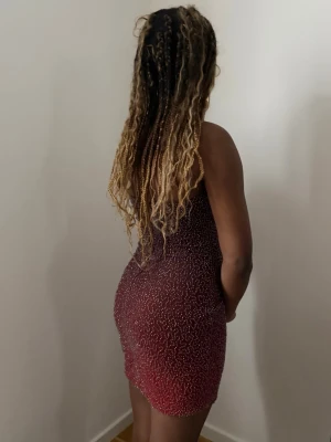 Röd glittrig axelbandslös kortklänning - Säljer en snygg axelbandslös kortklänning i röd ton med detaljer över hela tyget. Perfekt för dig som vill sticka ut på festen!💕UK 10 US 6