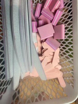 Nagel saker, allt säljs styck pris! Inget kit!! Kom dm för pris och vara  - Ett komplett nagelkit med flera nagelfilar, rosa och lila buffertblock samt olika burkar med färgglatt glitter och dekorationer. Perfekt för att fixa snygga naglar hemma. Materialen är bland annat skum, sandpapper och plast.