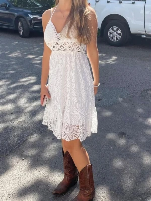 Vit klänning - Säljer en vit sommarklänning med fina detaljer, köpt i en butik i USA. Står inte storlek men den passar mig som har xs/s. Kom gärna med prisförslag!