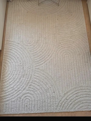 Ljusbeige matta med mönster - Säljer en sliten matta, den ser använd ut och har några små fläckar på mattan. Storlek 140 meter * 200 meter 