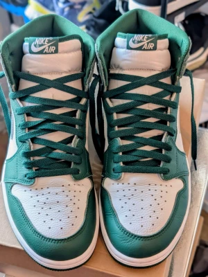 Nike Air Jordan 1 Pine green - Clean colorway som fungerar året runt och passar lika bra till wide pants, cargos eller mer minimalistiska fits. Väldigt fina i lädret och fortfarande fräscha både visuellt och på foten.  Original Nike Jordan  Ingen box  Bra skick på sulor och överdel  Bekväma och lätta att styla   Inte den vanligaste färgen man ser ute heller, vilket gör att de sticker ut lagom utan att bli för mycket.