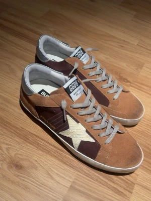 Unika bruna Golden goose - Ett par tvärfeta skor från golden goose perfekta inför sommaren. Stilrena med en fantastisk vaddad insida för maximal komfort. Skorna är helt nya och förvärvade genom leverantör. Skickar snarast och priset är självklart diskuterbart vid snabb affär, så bara att komma med bud. Vid fler frågor/bilder är det bara att höra av sig! (Skorna är i storlek 42 men passar även 43)