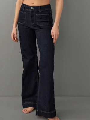 Mörkblå bootcut jeans med fickor - Snygga mörkblå bootcut jeans med hög midja och stora framfickor. Jeansen har kontrastsömmar och klassiska bakfickor. Tillverkade i kraftig denim som ger en schysst siluett och retrovibe.