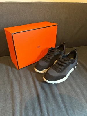 H skor  - Stilrena svarta sneakers med chunky vit sula och svarta skosnören. Skorna har en modern design med blandning av mocka och textilmaterial. Perfekta för dig som vill ha en lyxig och trendig look.