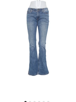 Blå bootcut jeans med milt utsvängda ben - Snygga blå bootcut jeans med klassisk femficksdesign och utsvängda ben. Jeansen har normalhög midja och är tillverkade i denim med lätt tvättad look. Perfekta för dig som gillar retrostil och vill ha ett par jeans som sticker ut. Jag skulle säga att dessa är mer raka än bootcut som man ser på bild 3. De passar perfekt för en tidlös stil! Säljer då de är lite för stora för mig. Jag tror de här skulle vara perfekta för att sy om till bootcut om man önskar det.