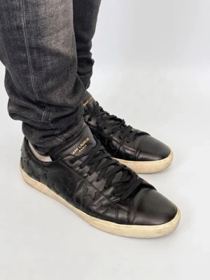 Saint Laurent SL 06 - Skorna är sparsamt använda och i absolut toppskick – helt utan defekter! Detaljer: Märke: Saint Laurent Modell: SL 06 Leather Low Top Sneakers Färg: Stilren svart Design: Klassisk rund tå med elegant snörning framtill Storlek: Herrstorlek US 10 / EU 43 Passform: Normala i storleken (True to size) 