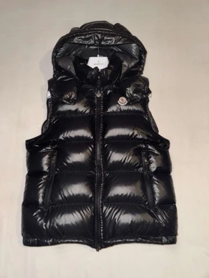 Moncler väst med luva - Hejsan jag säljer nu min moncler väst som är i jättebra skick, jag har inte andvänt den så mycket kanske 2/3 gånger jag säljer den pågrund av att den inte passade min stil, den är köpt ifrån Nk Göteborg och kvittot finns, Priset är hugget i Sten,  hör av dig vid minsta lilla fråga!🙌