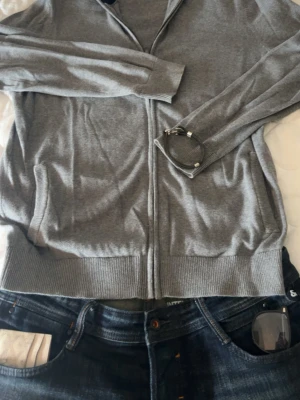 Grå ziptröja från Pier One - Grå ziptröja från Pier One med ribbade muddar. Tröjan har dragkedja framtill och två fickor. Perfekt för en avslappnad och stilren look. Den är tun så passar till sommaren helt ny har antvänts 5 gånger. 