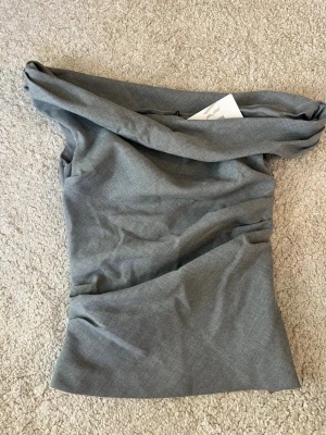 Grå offshoulder topp Zara  - Snygg grå offshoulder topp från Zara i storlek S. Helt i nyskick med lapp kvar. Säljes då den ej kommer till användning. Pris kan diskuteras ☺️