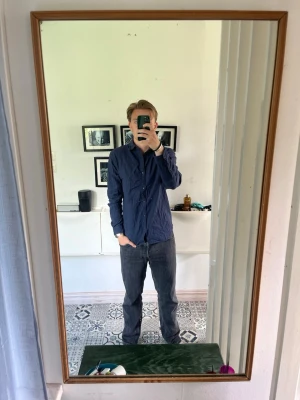 Mörkblå skjorta Jack & Jones S - Säljer en stilren mörkblå skjorta med klassisk krage och knäppning framtill i storlek S. Skjortan har lång ärm och en rak passform som funkar till många olika looks. Perfekt för dig som gillar enkel och clean stil.