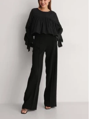 Svart volangblus  - Trendig svart blus med volangdetaljer och vida, långa ärmar. Blusen har en lös passform och är kroppad. Perfekt för att styla en edgy eller coolare look.
