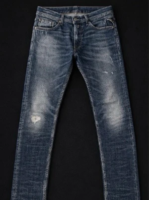 Blå slim fit jeans från Replay - Snygga blå slim fit jeans från Replay med slitna detaljer och lätt tvättad look. Klassisk femficksmodell med dragkedja och knapp, samt Replay-lapp bak i midjan. Perfekta för en avslappnad och trendig stil. Riktigt fräscha och knappt använda💥💥