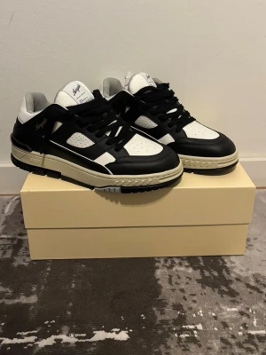 Svarta och vita Axel Arigato sneakers - Säljer mina Arigato area lo’s black/white som tyvärr aldrig kommit till användning, skorna är alltså helt nya och har inte ens testats.  Digital kvitto finns på skorna. Extra par vita snören+Arigato väska följer med på köpet. Storlek 42 / US 9