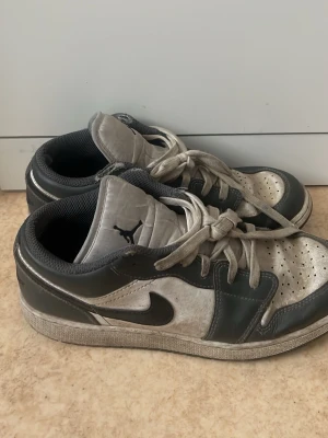 Gråa Air Jordan 1 Low sneakers - Snygga Air Jordan 1 Low sneakers. Det är storlek 39 på dom, väl använda men funkar fortfarande. Ja dom är lite smutsiga men kan tvätta dom lite lätt om någon är sugen å köpa!