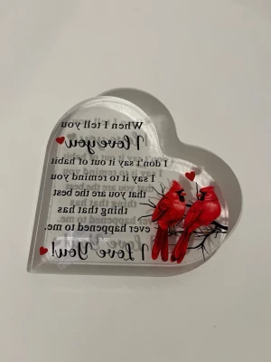 Hjärta med röda fåglar och text - Dekorativt hjärta i genomskinlig akryl med två röda kardinalfåglar på en gren och texten 'When I tell you I love you...'. Perfekt som personlig present eller minnessak. Fina röda detaljer och romantiskt motiv.              Fick det för inte så länge sen och vet tyvärr inte var den är ifrån.