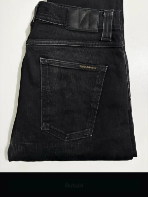 Svarta Nudie Jeans - Snygga svarta Nudie jeans. 29/32. Snygga jeans i bra skick, har endast ett litet skav i fram nedanför gylfen som man inte tänker på.