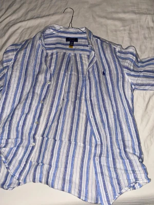 Ralph lauren skjorta randig - Jag säljer denna snygga skjortan då jag växt ifrån den. Det är storlek L i barnstolek alltså 14-16 år. Den passar mig, jag är 175 68 KG så skulle påstå att den är närmare xs/S. Har du några frågor så är det bara att kontakta mig, priset är ej hugget i sten. Inte använd så mycket helt felfri skick 9/10