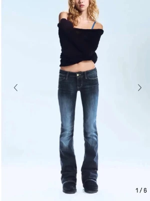 Bootcut jeans från Cheap Monday - Mörkblå bootcut jeans från Cheap Monday med snygga slitningar och klassisk femficksdesign. Jeansen har låg midja och orangea detaljer vid bakfickan. Perfekta för dig som gillar en avslappnad men trendig look.