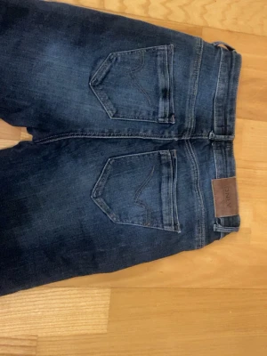Bootcut jeans från Only - Säljer ett par mörkblå bootcut jeans från Only med klassiska bakfickor och snygg wash. Jeansen har en lätt utsvängd passform nedtill och är gjorda i mjukt denimtyg. XS, längd 30