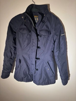 Woolrich jacka - Blå Woolrich jacka. Riktigt snygg färg o snygg modell. Storlek XS. Jackan är i riktigt bra skick. Perfekt för våren.