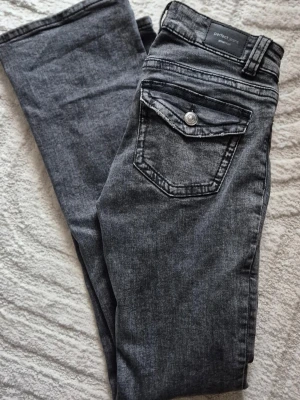 Low waist jeans Gina, bootcut stl 34 - Nästan nya jeans (använda ett par ggr, tvättade en gång) från Gina Tricot. Utsvängda ben dvs bootcut, snygga fickor med lock bak. Låg midja. Stl 34. 98% bomull, 2% elastan.