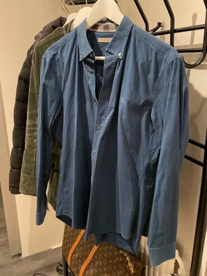Burberry skjorta - Snygg skjorta från Burberry med en snygg marinblå liknande färg. Den har deras klassiska mönster på både insida krage men också i ärmarna. 9/10 skick helt felfri. 🔥Bara höra av sig i dm vid frågor och funderingar!🔥(Bild med den på kan visas i dm)‼️