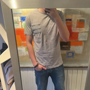 Grå t-shirt med fickdetaljer - Från Han Kjøbenhav, storlek XL. Bra skick
