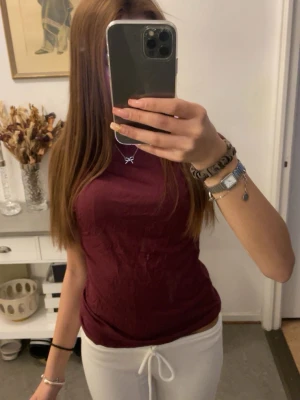 Mörkröd ärmlös topp - Snygg mörkröd ärmlös topp med rund halsringning. Enkel och stilren design som passar perfekt till både jeans och kjol. Tillverkad i mjukt material som känns skönt mot huden.