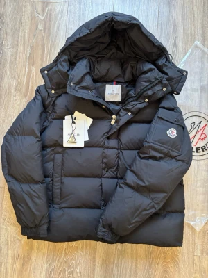 Moncler jacka - Säljer en helt ny svart Moncler Vezere jacka. Har scan. Storlek 3 (L) men passar även 2 (M). Kan sänka pris för snabb affär. Finns fler spännande artiklar på profilen!!