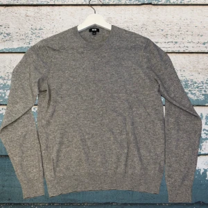 Grå tröja från uniqlo (100% Kashmir)  - Klassisk grå stickad tröja från Uniqlo med rund halsringning och långa ärmar. Tröjan har ribbade muddar vid ärmslut och nederkant. Perfekt basplagg i 100% Kashmir som passar till det mesta. Ny pris 1499kr 