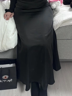 Svart lång kjol  - Stilren svart lång satin kjol