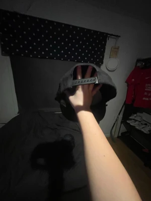 Svart snapback-keps  - Säljer en svart snapback-keps från Napapijri med klassisk böjd skärm och justerbar plastrem bak. Kepsen har en stilren look utan synliga mönster eller loggor framtill och är tillverkad i ett slitstarkt material. Jag har använt den svarta två gånger och den blå nol gånger