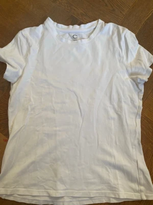 Vit basic t-shirt i bomull - En klassisk vit t-shirt från C med rund hals och korta ärmar. Tillverkad i mjuk bomull som känns skön mot huden. Perfekt att matcha med jeans eller shorts för en enkel och clean look.