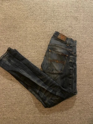 Nudie jeans - Säljer ett par snygga jeans från nudie. Byxorna är i rätt bra skick men säljer eftersom att dom är för små för mig. Storleken ser ni på sista bilden. Färgen är lite mörkblå och shading till ljusblå. Hör av er om ni är intresserade.