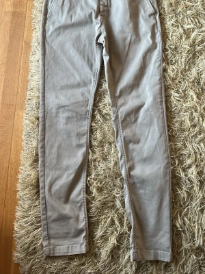 Replay byxor - Snygga beige chinos från Replay med klassisk rak passform. Byxorna har framfickor, bakficka med knapp och bälteshällor. Tillverkade i ett mjukt bomullsmaterial som ger en skön känsla och stilren look.