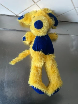 Sverige Mascot Gul och blå mjukisdjur hund - Sverige  Mascot  cs 50 lång Säljer ett gulligt mjukisdjur i form av en hund med lång gul päls och blå detaljer på nos, öron, mage och tassar. Perfekt som present eller dekoration. Mjuk och fluffig, enkel att krama och ha med sig.