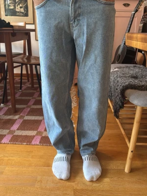 Ljusblå raka jeans - Säljer ett par ljusblå jeans med rak passform och hög midja. Klassisk femficksmodell i mjukt denimtyg, perfekta för en avslappnad och trendig look. Inga synliga loggor eller märken på jeansen.